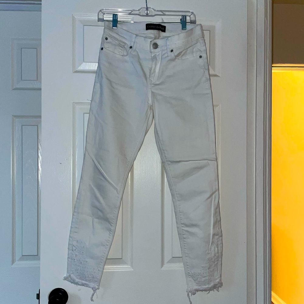 Express white denim with embroidery detail & raw hem.